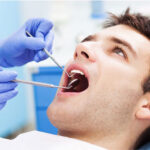 man gets an oral cancer screening at the dentist office