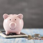 piggy bank and calculator to show savings from dental membership plan at Caring Smiles Dental