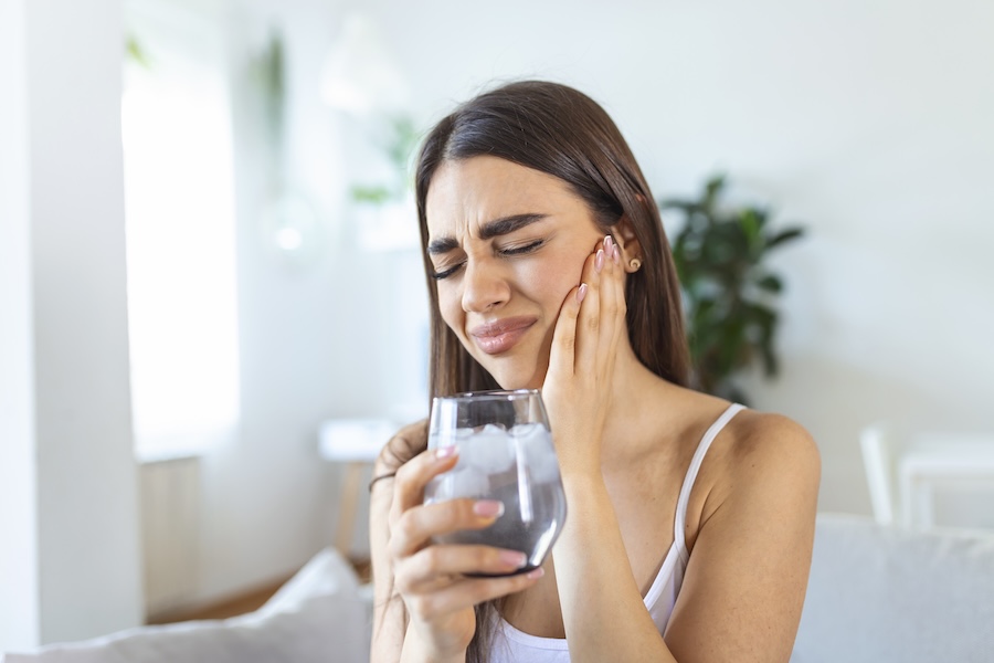 woman with tooth sensitivity or sensitive teeth after drinking ice water