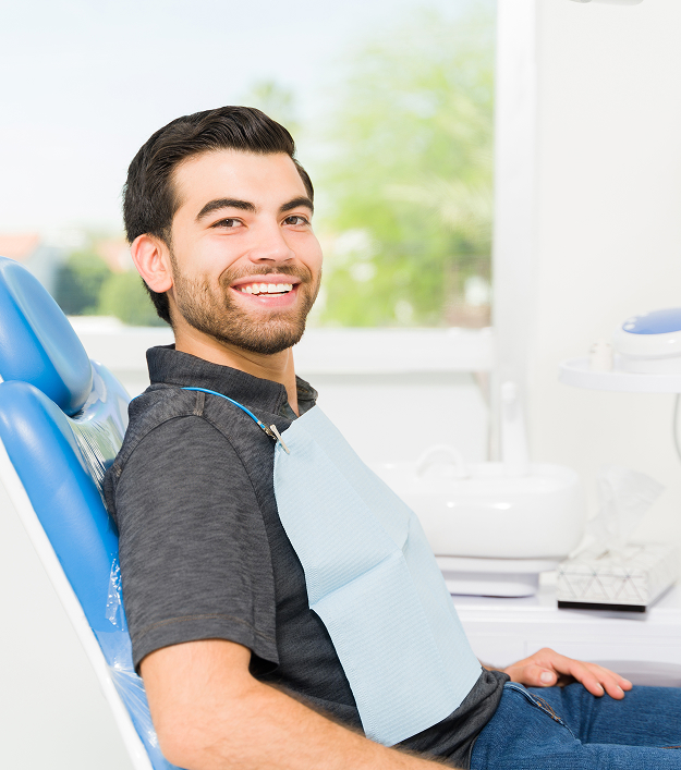 smiling man sitting in a dental chair